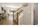 Welcoming hallway with wooden staircase and views into the bright and airy living room at 11886 E Fair Ave, Greenwood Village, CO 80111