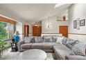 Bright living room with vaulted ceiling, skylights, and a large comfy sectional sofa with view of the front yard at 4231 S Fairplay Cir # A, Aurora, CO 80014