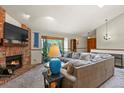 Comfortable living room featuring a cozy fireplace, large window and large gray sectional sofa at 4231 S Fairplay Cir # A, Aurora, CO 80014