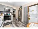 Modern kitchen with stainless steel appliances, light gray cabinets, and washer-dryer closet at 1143 Lamar St # 6, Lakewood, CO 80214