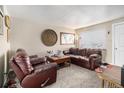 Cozy living room with neutral carpet, a large window, and comfortable leather furniture at 1143 Lamar St # 6, Lakewood, CO 80214