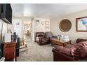 Inviting living room featuring neutral carpet, comfortable seating, and access to the dining area at 1143 Lamar St # 6, Lakewood, CO 80214
