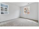 Well-lit bedroom with neutral carpeting and large windows overlooking the neighborhood at 8480 Eagle River St, Littleton, CO 80125