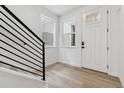 Bright entryway featuring wood-look floors, modern staircase, and large windows at 8480 Eagle River St, Littleton, CO 80125
