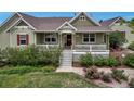 Inviting front porch with white railing, quaint seating, and beautifully landscaped front yard at 3545 Cottonwood Cir, Longmont, CO 80504