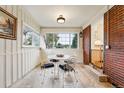 Bright sunroom dining area featuring large windows and a charming table set, perfect for enjoying meals with a view at 8736 W 46Th Ave, Wheat Ridge, CO 80033