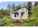 View of home showing vibrant landscaping and outdoor charm at 5071 Parmalee Gulch Rd, Indian Hills, CO 80454