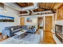 Well-lit living room with exposed ductwork, brick accents, hardwood floors, and comfortable gray sectional at 1465 S Pearl St # 6, Denver, CO 80210