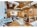 Open living space with exposed ductwork and wooden ceilings, a cozy fireplace, and comfortable seating at 1465 S Pearl St # 6, Denver, CO 80210
