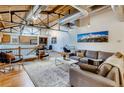 Bright living room featuring exposed brick, ductwork, wooden ceilings and a comfortable seating arrangement at 1465 S Pearl St # 6, Denver, CO 80210