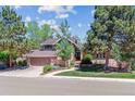 Beautiful home exterior showcasing a two-car garage, brick accents, and a professionally landscaped front yard at 5373 E Links Cir, Centennial, CO 80122