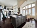 Open-concept kitchen flows into the living area with large windows and a fireplace at 6561 Ocaso Dr, Castle Pines, CO 80108