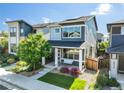 Charming two-story home featuring a cozy front porch with a hanging swing and beautifully landscaped yard at 6940 Clay St, Denver, CO 80221
