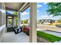 View from the porch of a neighborhood street with a swing, flowers and manicured lawn at 6940 Clay St, Denver, CO 80221