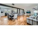 Bright living space with hardwood floors, dining table, kitchen with island and stainless appliances at 8007 S Dover St, Littleton, CO 80128
