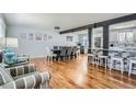 Open-concept living space with hardwood floors, dining area and stylish kitchen with bar seating at 8007 S Dover St, Littleton, CO 80128