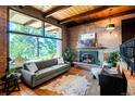 Inviting living room boasts brick walls, a cozy fireplace, and expansive windows with lovely outdoor views at 21868 Mountsfield Dr, Golden, CO 80401