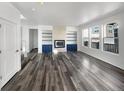 Bright living room featuring hardwood floors, built-in shelves, and a modern fireplace at 4940 Akron St, Denver, CO 80238