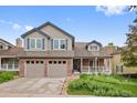 Inviting two-story home with brick accents, a covered porch, and an attached two-car garage at 18 Blue Sage, Littleton, CO 80127