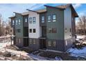 Three-story townhomes with a mix of green, white, and gray siding at 5193 Carr St, Arvada, CO 80002