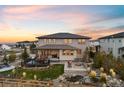 Expansive backyard featuring a cozy fire pit, outdoor seating, and meticulously designed landscaping at 6405 Kenzie Cir, Castle Pines, CO 80108