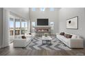 Bright, open living room with a fireplace, soaring ceilings, and lots of natural light at 6405 Kenzie Cir, Castle Pines, CO 80108