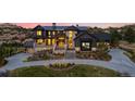 Grand home with stone accents, a well-manicured lawn, and mature landscaping creates an inviting curb appeal at 7868 Cicero Ct, Littleton, CO 80125