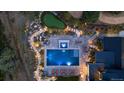 Aerial view of a luxurious pool with a waterfall feature, stone paths, and a putting green at 7868 Cicero Ct, Littleton, CO 80125