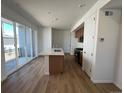 Modern kitchen with a large island, stainless steel appliances, and sliding glass door to the patio at 6648 N Nepal Ct, Aurora, CO 80019