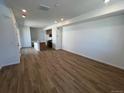 Open-concept living room featuring hard wood floors with an adjacent kitchen, perfect for entertaining at 6648 N Nepal Ct, Aurora, CO 80019