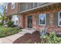Close-up of brick home entrance with wrought iron security door and blooming flower bed at 7355 S Knolls Way, Centennial, CO 80122