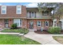 Inviting brick townhome with a cozy second-story balcony and well-maintained landscaping at 7355 S Knolls Way, Centennial, CO 80122