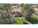 Charming brick townhome with a second-story balcony surrounded by mature trees at 7355 S Knolls Way, Centennial, CO 80122
