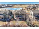 Back of home with large deck overlooking fenced yard and views of the community with pond and green spaces at 7680 S Blackstone Pkwy, Aurora, CO 80016