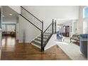 Elegant entryway with hardwood floors, a staircase with an iron railing, and a view into the living room at 7680 S Blackstone Pkwy, Aurora, CO 80016
