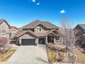 Charming two-story home boasting a stone facade, attached two car garage, and cozy front porch at 7680 S Blackstone Pkwy, Aurora, CO 80016