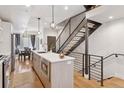 Bright, open kitchen with stainless steel appliances, an island, and modern lighting fixtures at 1836 Grove St # 108, Denver, CO 80204