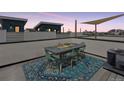 Rooftop deck features an outdoor dining set, shade, and city views at 1836 Grove St # 108, Denver, CO 80204