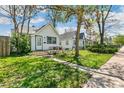 Quaint home featuring a small front porch and a grassy yard with a mature tree at 1850 S Williams St, Denver, CO 80210