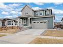 Attractive two-story home featuring a two-car garage, a front porch, and blue siding at 12777 Clearview St, Firestone, CO 80504