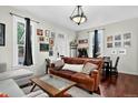 Inviting living room with hardwood floors, leather sofa, large windows, and stylish decor at 1448 Depew St, Lakewood, CO 80214