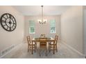 Dining room features a modern chandelier, large clock, and natural light at 6092 S Ouray St, Aurora, CO 80016