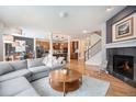 Open-concept living room features a fireplace, wood floors, and comfortable gray couch at 6092 S Ouray St, Aurora, CO 80016