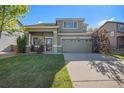 Charming two-story home featuring a well-manicured lawn and a two-car garage at 10359 Tracewood Dr, Highlands Ranch, CO 80130