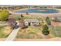 Aerial view of house, with large yard, mature landscaping, driveway, trees, and white picket fence at 212 Mulligan Lake Dr, Mead, CO 80542