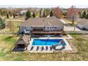 Aerial view of in-ground pool, hot tub, gazebo, large deck, patio and manicured lawn at 212 Mulligan Lake Dr, Mead, CO 80542