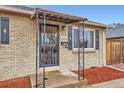 Inviting covered porch with ornamental ironwork and brick exterior at 3020 Niagara St, Denver, CO 80207