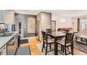 Kitchen with stainless steel appliances, dining area, wood floors, and modern finishes at 3020 Niagara St, Denver, CO 80207