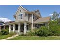 Stylish gray two-story house showcasing a cozy front porch and lush greenery at 3354 Wabash St, Denver, CO 80238