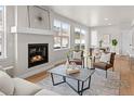 Bright living room with hardwood floors, large windows, and a cozy fireplace at 4888 Noris Ave, Morrison, CO 80465